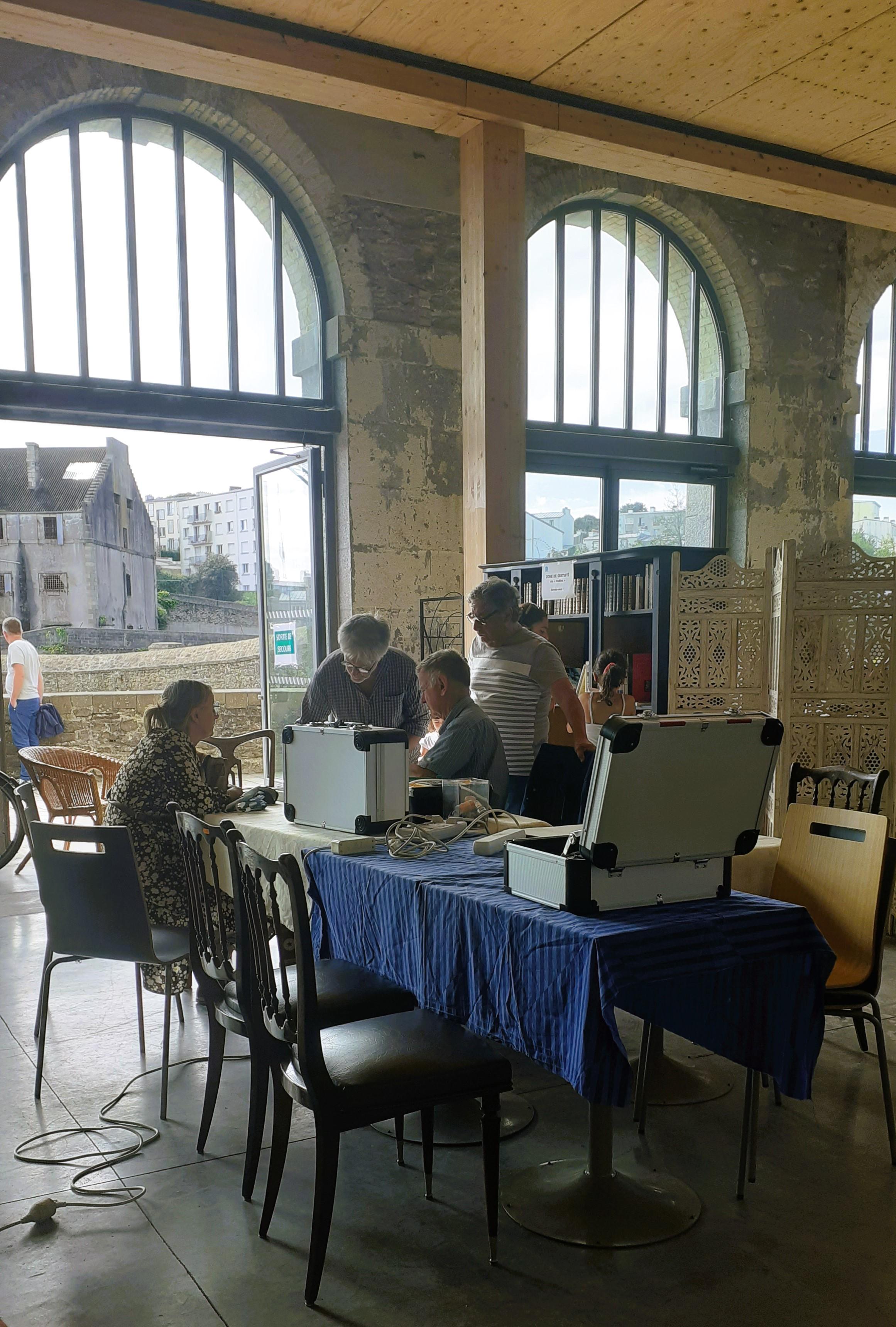 Réparateurs bénévoles autour de la table de réparation