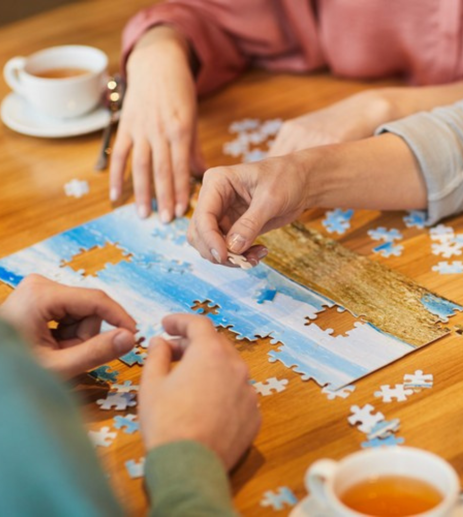 Personnes en train de faire un puzzle en buvant un thé