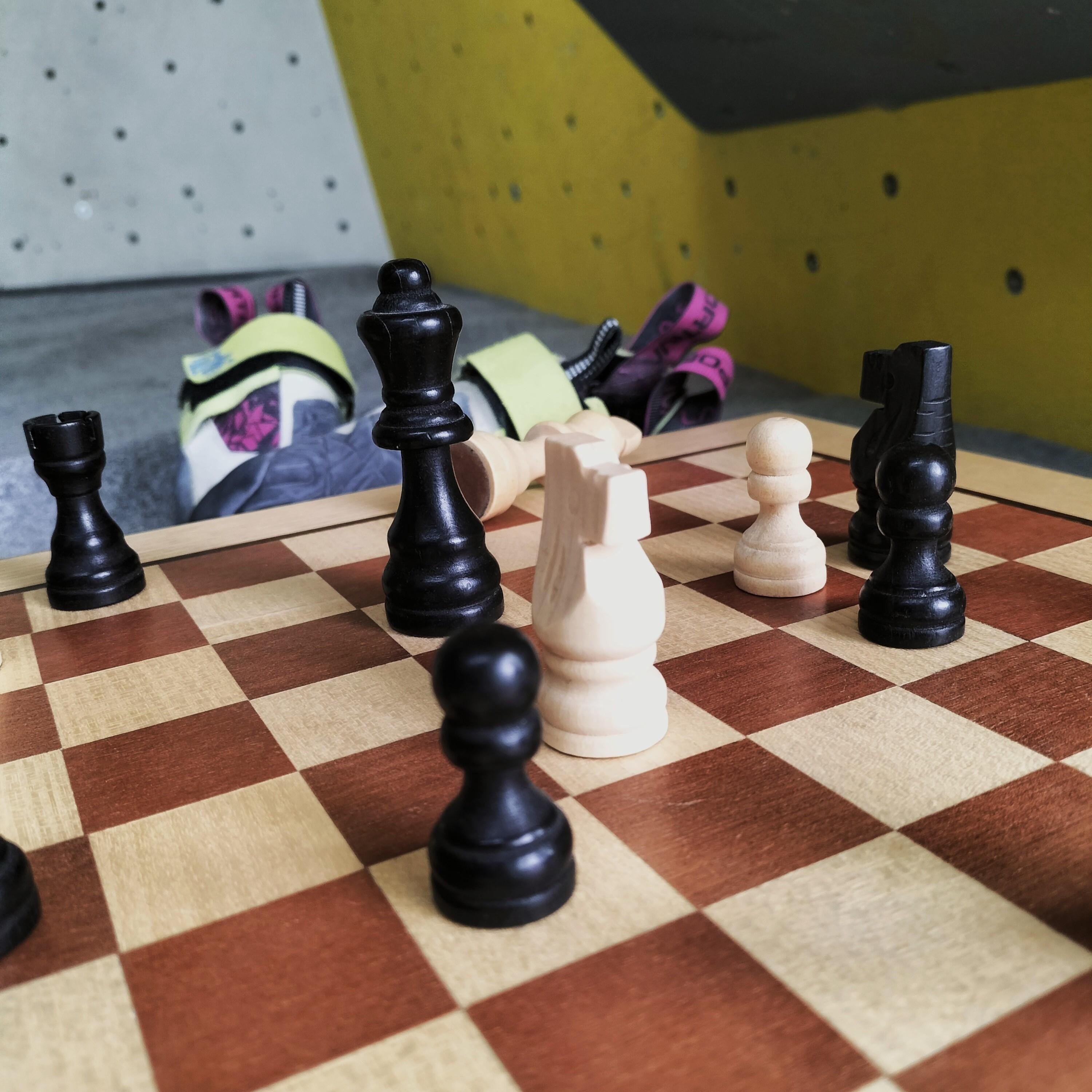 Jeu d'échecs devant un mur d'escalade