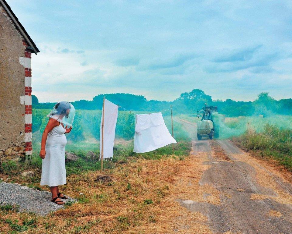 Photographie représentant une femme enceinte et un véhicule diffusant des produits chimiques